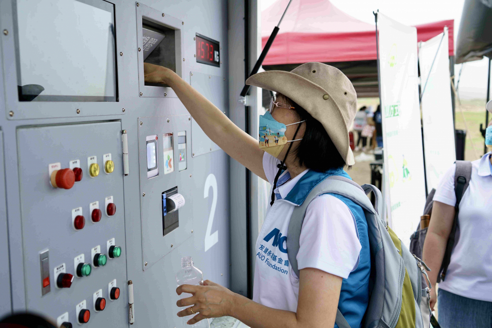 志工們將拾起的寶特瓶投入「好歸塑專車」，讓廢棄塑料空瓶可以直接粉碎、縮小體積，未來將可再製成購物袋、寶特衣、悠遊卡等生活用品